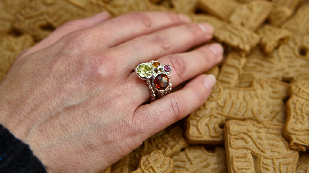 Goldschmiede-Ring an der Hand, Hintergrund weihnachtlicher Spekulatius