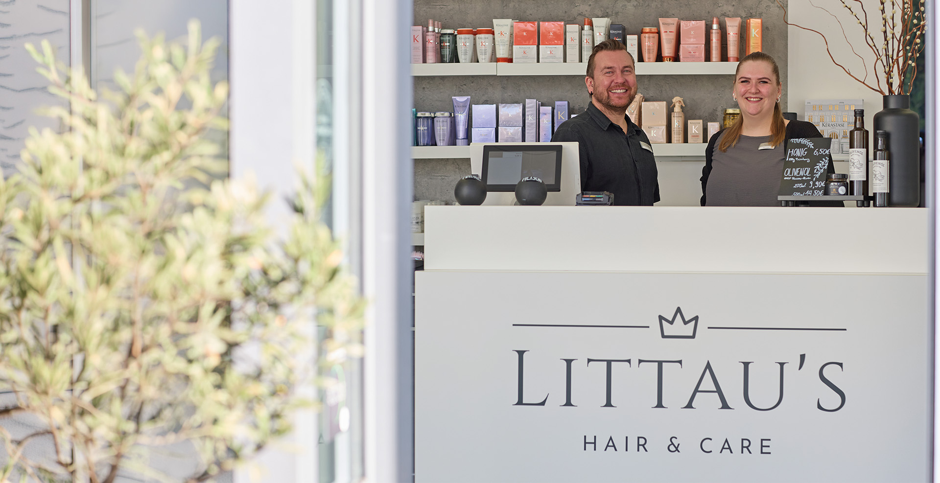 Zwei Mitarbeiter eines Geschäftes stehen an der Eingangspforte